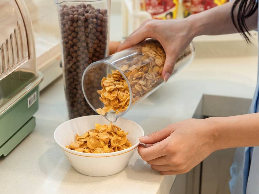 A person pouring cereal into a bowl.