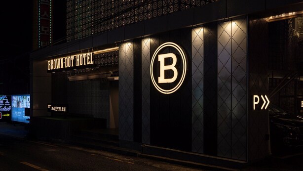 The exterior of the Browndot Hotel with a prominent 'B' logo and a parking sign.