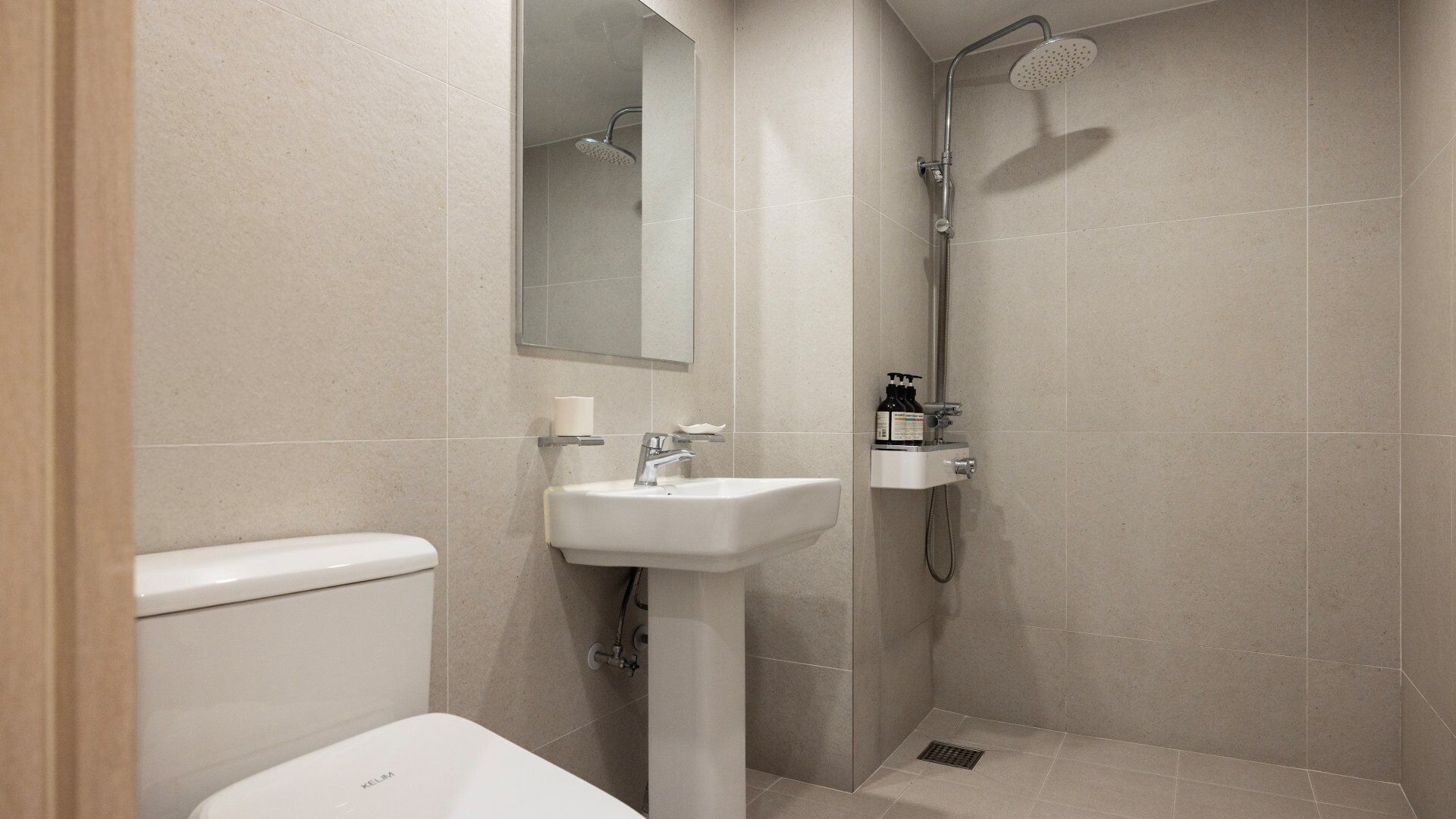 A modern bathroom with a toilet, sink, and shower.