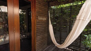 A wooden structure with a hammock, a wooden door, and a sign that reads "kinkajou".