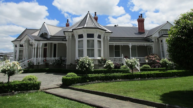 A large, white, two-story house with a wrap-around porch and multiple chimneys. - Valmai House & Motel (Cambridge)