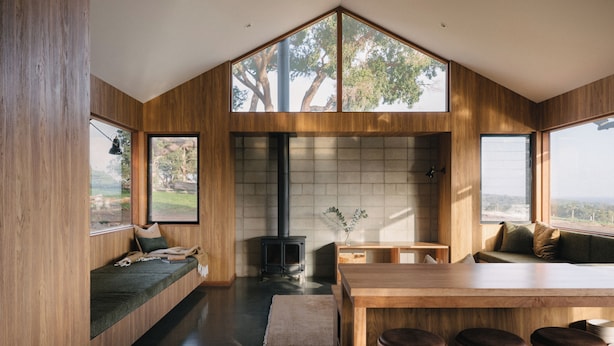 A modern kitchen with a wood finish, a built-in stove, and large windows offering views of the outdoors. - Wildwood Barn: New Luxe Home, Valley Views, Outside Bath, Firepit & Ocean Views (Yallingup)