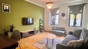 Ein Wohnzimmer mit Fernseher, Sofa und Couchtisch.