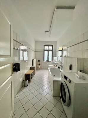 Ein modernes Badezimmer mit Waschmaschine, Waschbecken und Toilette.