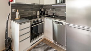 Una cocina moderna con electrodomésticos de acero inoxidable, horno empotrado y lavavajillas.