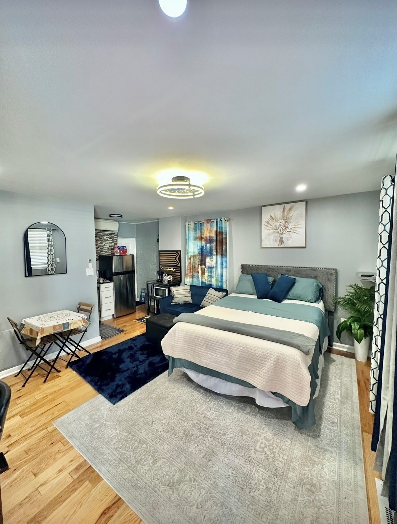 Une chambre moderne avec un grand lit, un bureau et un coin repas.