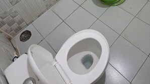 Un bagno con un water, un bidet verde e un lavandino.