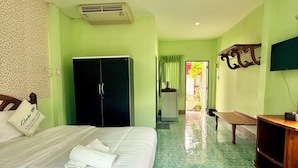 A hotel room with a bed, a wardrobe, a desk, and a television. - Wave point resort  (Pattaya)