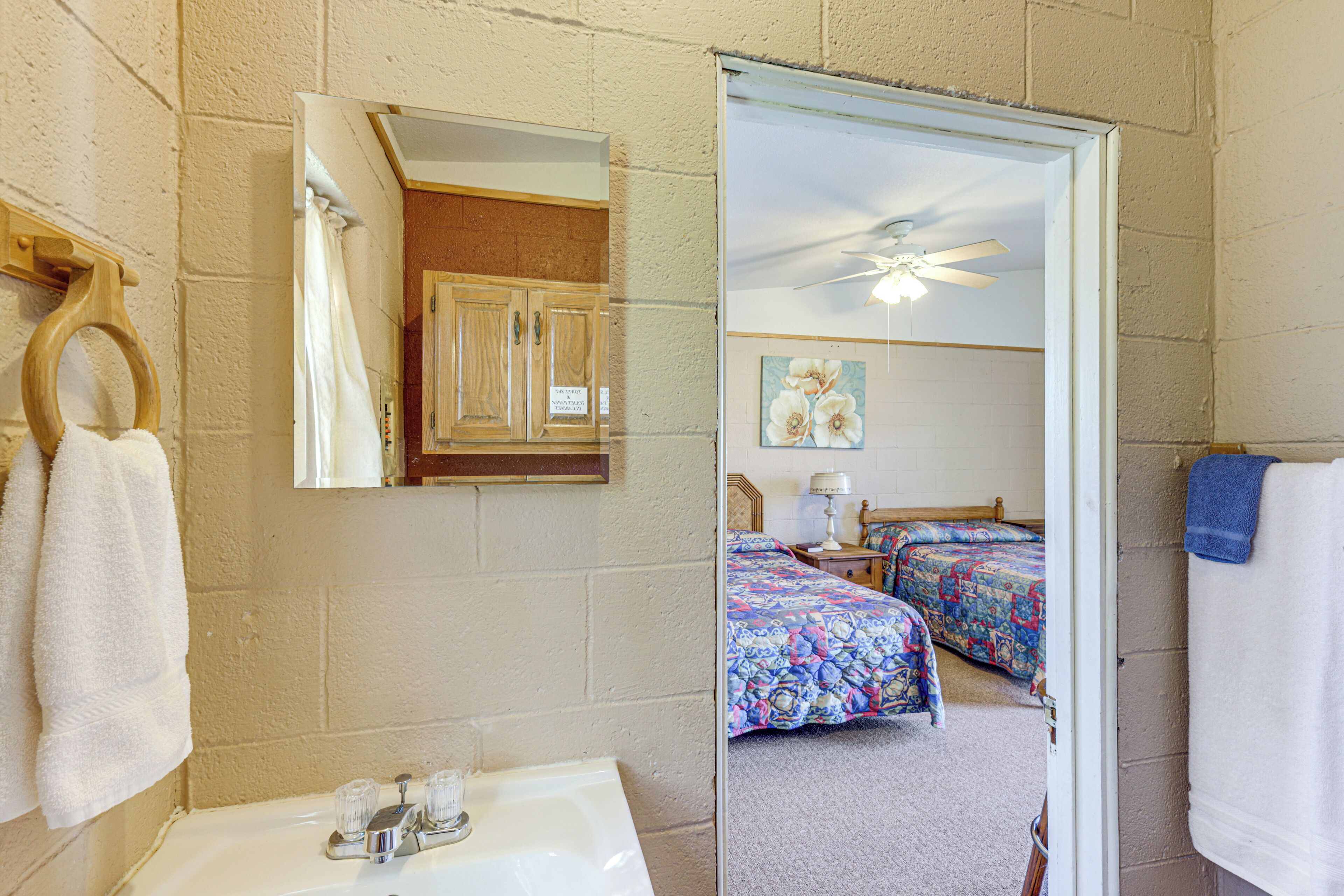 A bathroom with a sink, mirror, and towel rack.