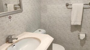 Ein Badezimmer mit Waschbecken, Toilette und Handtuchhalter.