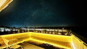 A rooftop terrace with a starry night sky, a pool with yellow lighting, and a chair. - Ambient lounge with sundeck and free parking (Bratislava)