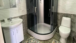 A modern bathroom with a glass-enclosed shower, a sink, and a toilet. - Paradise Villa (Taldykorgan)