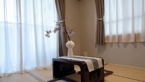 A room with tatami flooring, a low table with a vase of flowers, and sheer curtains. - Shinjuku commercial area-Shinjuku Area-East Shinjuku Shinjuku-2Room-Max5P-Japanese style-Ueno Shinjuku-Ikebukuro-Shibuya Direct access (新宿区新宿)