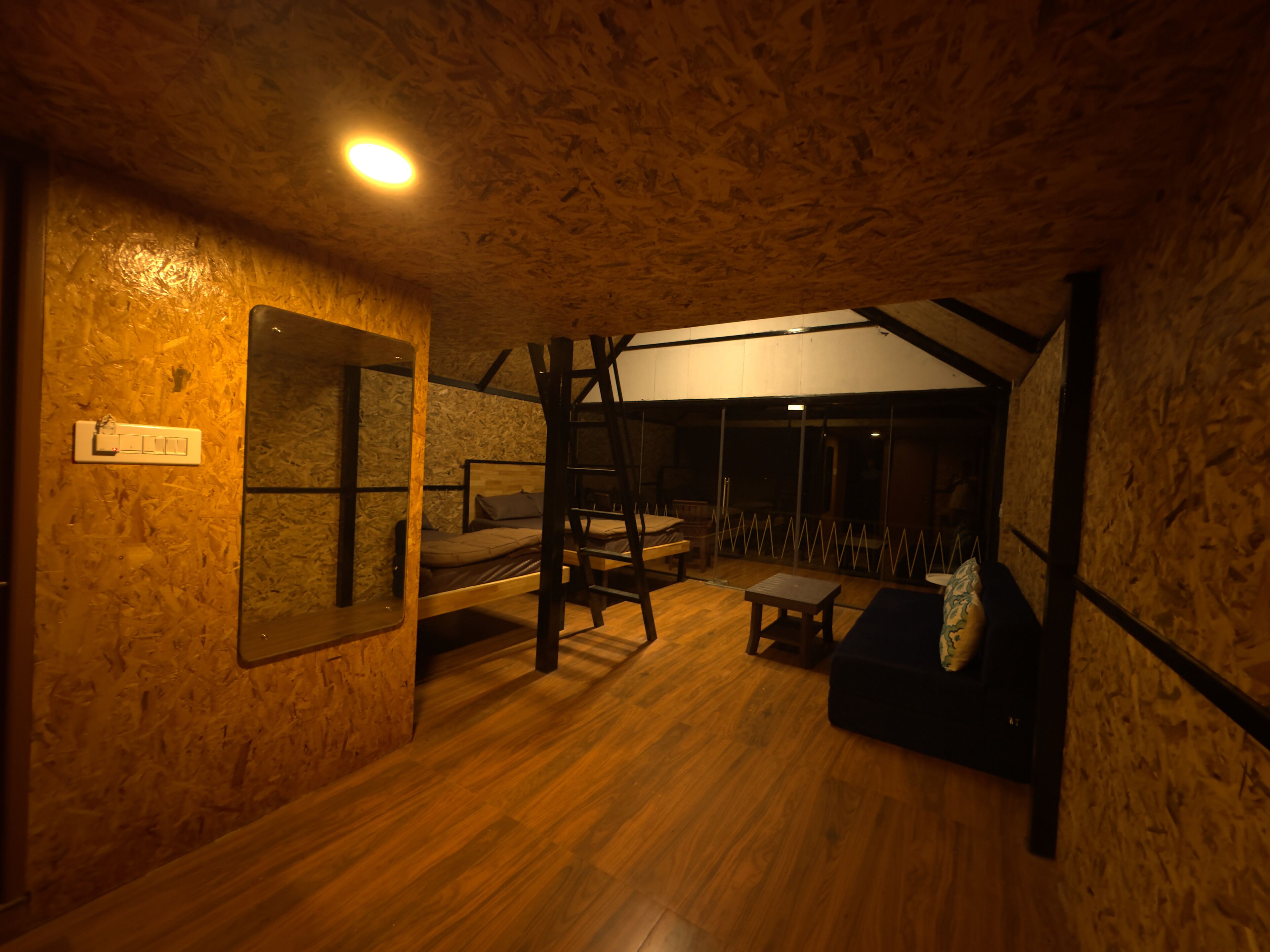 A cozy room with a bunk bed, a small table, and a couch.