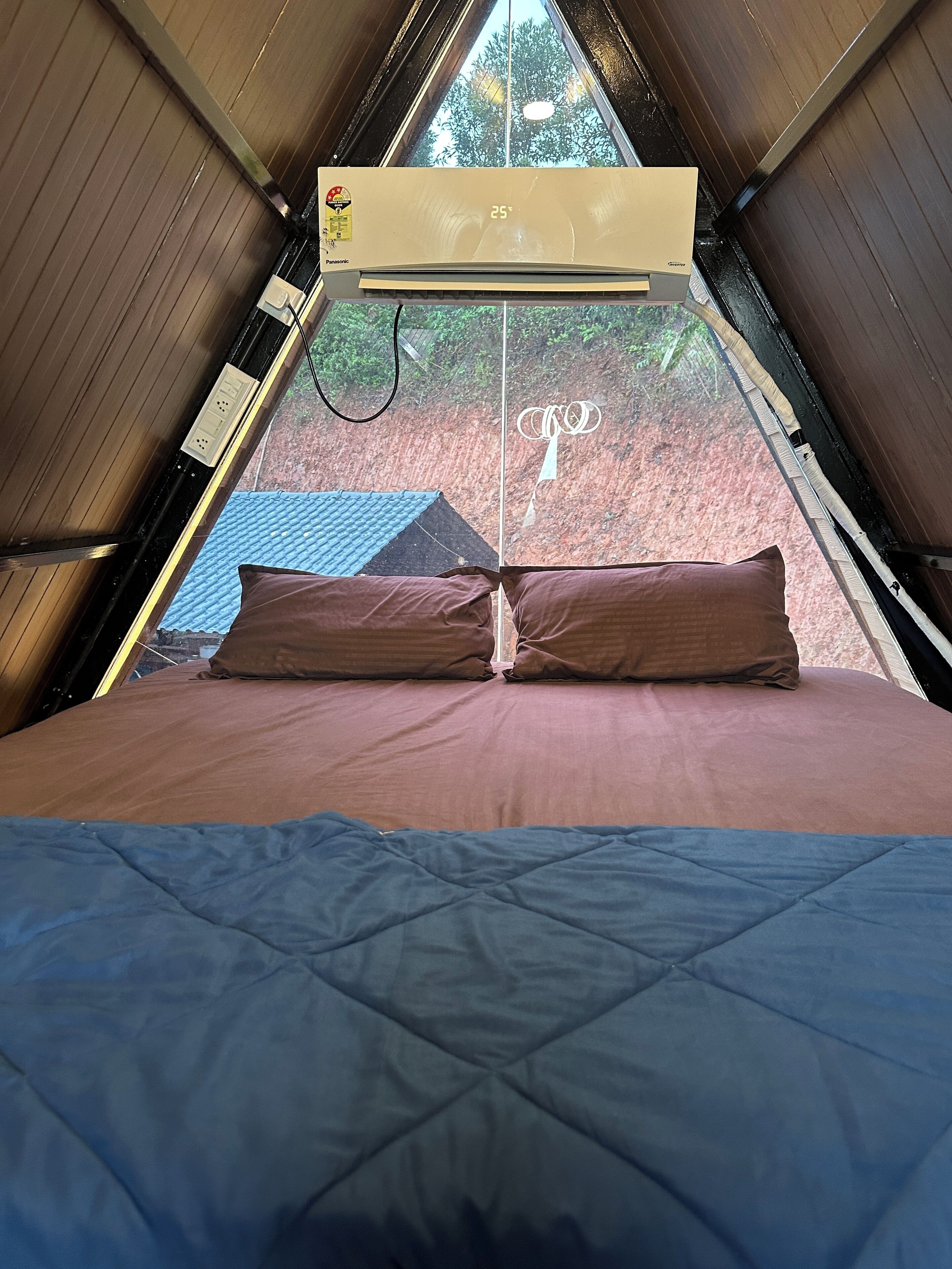 A room with a bed, a window, and a ceiling fan.