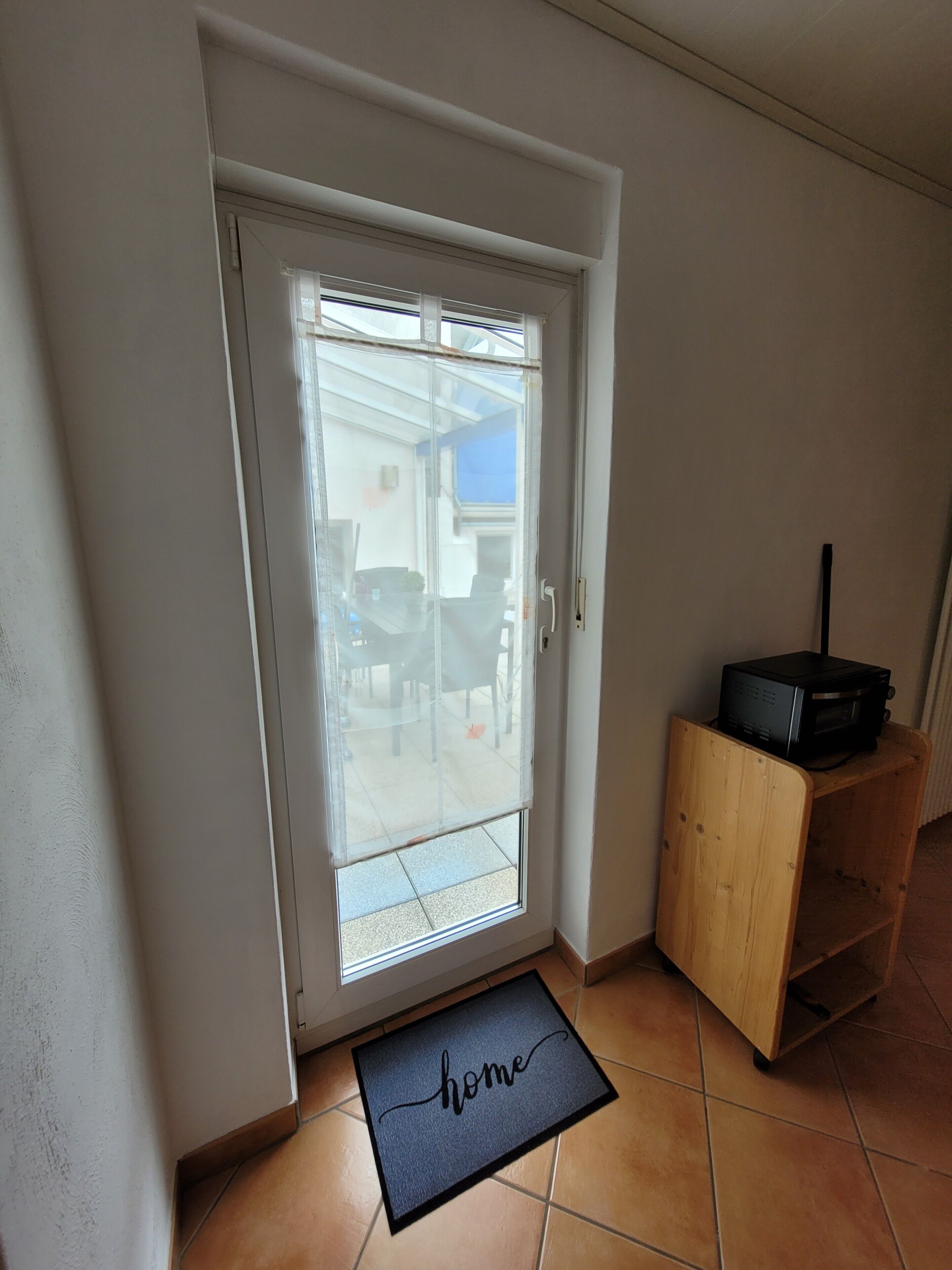 A door with a glass panel, a wooden cabinet, and a doormat with the word 'home' on it.