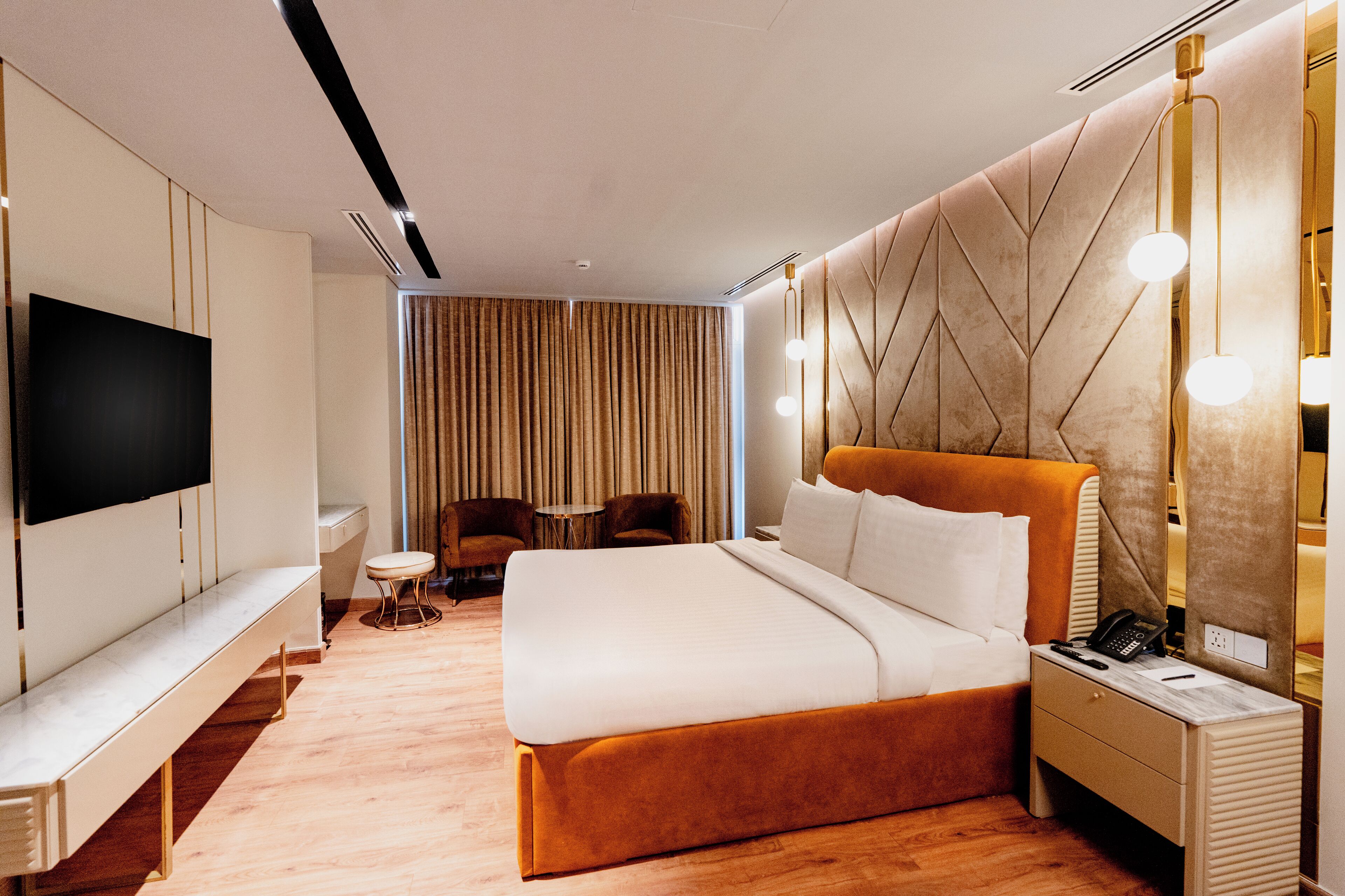 Habitación de hotel moderna con una cama grande, televisión, escritorio y silla.