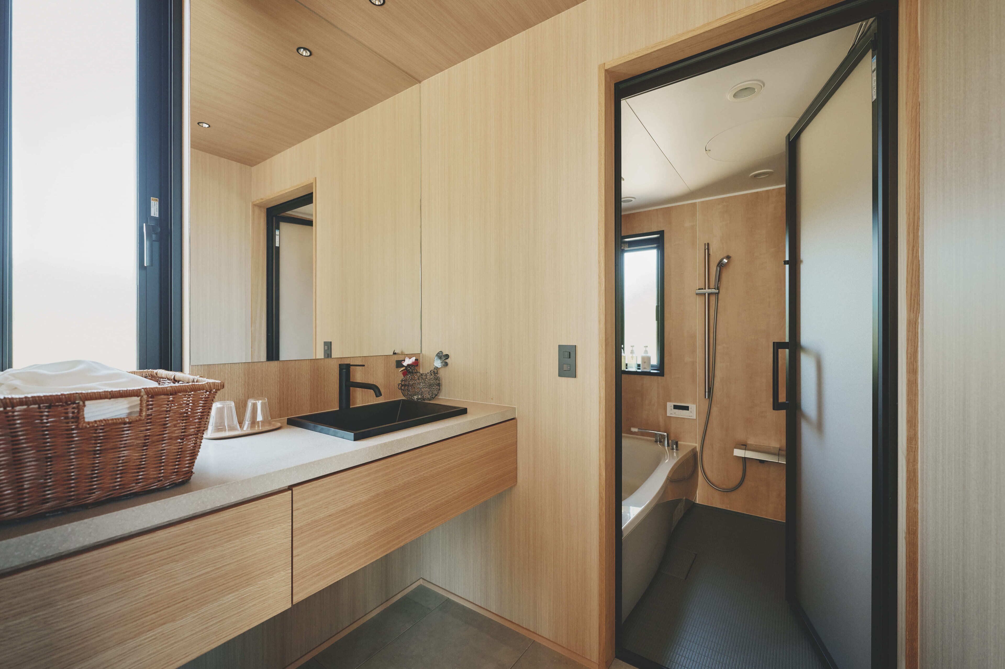 A modern bathroom with a wooden vanity, a sink, and a shower.