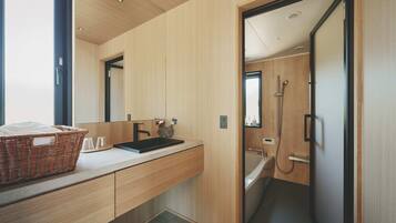 A modern bathroom with a wooden vanity, a sink, and a shower.