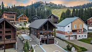 A lodge with multiple wooden buildings, a central building with a balcony, and a view of a mountainous landscape. - Black Bear Lodge (Snoqualmie Pass)