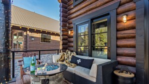 A log cabin with a stone fire pit, outdoor seating, and a large window. - Black Bear Lodge (Snoqualmie Pass)
