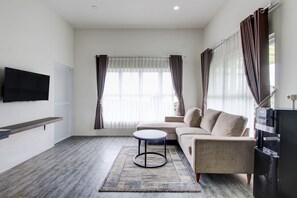 Deluxe Double Room | Living room | 32-inch flat-screen TV with cable channels