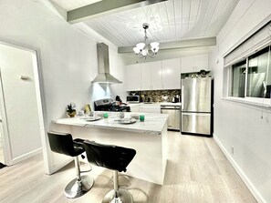 A modern kitchen with a central island, stainless steel appliances, and a chandelier. - Lime & Oak: Tech Ready 2BR Willow Glen
Oasis (San Jose)