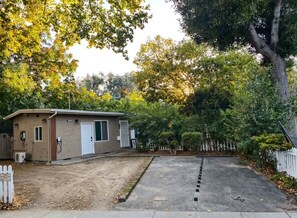A single-story building with a garage, surrounded by trees and a white picket fence. - Lime & Oak: Tech Ready 2BR Willow Glen
Oasis (San Jose)