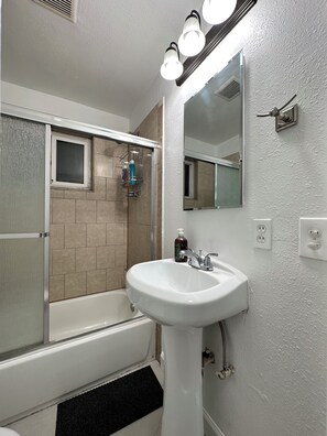 Un baño con bañera, lavamanos y ducha.