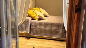 Une chambre à coucher avec un lit, une table de chevet et une fenêtre avec des rideaux.