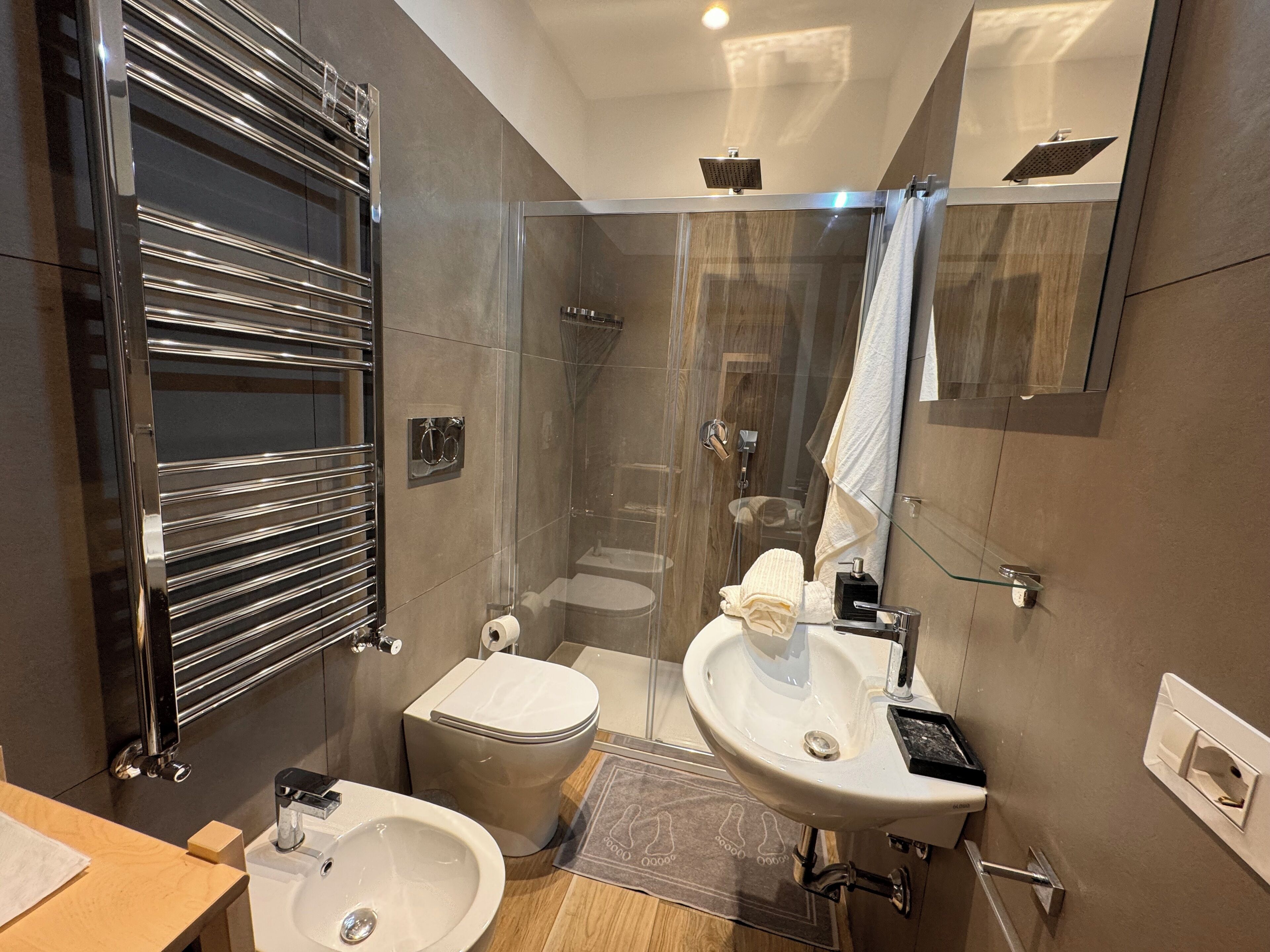 Ein modernes Badezimmer mit einer Duschkabine, einer Toilette und einem Waschbecken.