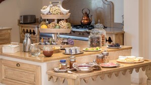 Uma mesa de buffet com diversos alimentos, acompanhamentos e elementos decorativos.
