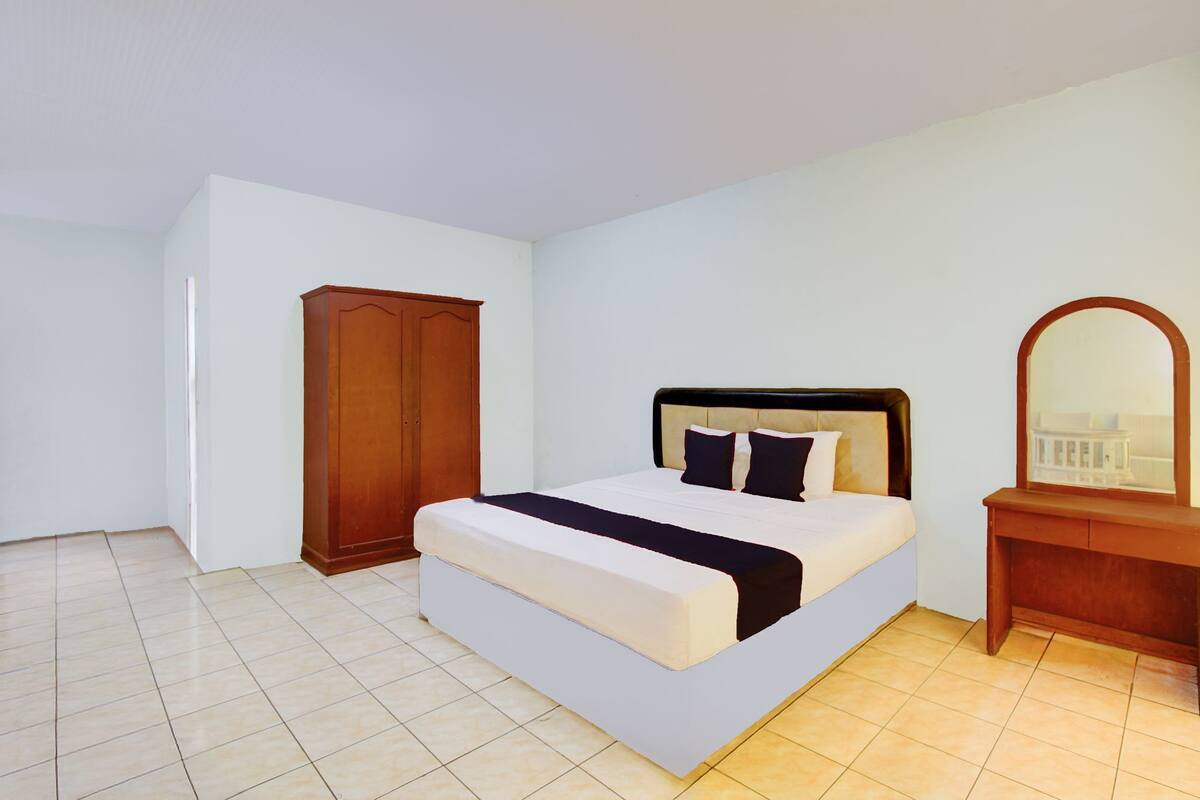 Une chambre à coucher avec un lit, une armoire et un miroir.