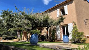 A building with a tiled roof, a garden with a palm tree, and two large blue planters. - Family house - Country house - Holiday home (Grimaud)