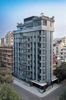Un edificio moderno de varios pisos con balcones, ventanas amplias y techo plano.