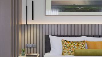 A modern bedroom with a bed, a nightstand, a framed landscape painting, and a pendant light.