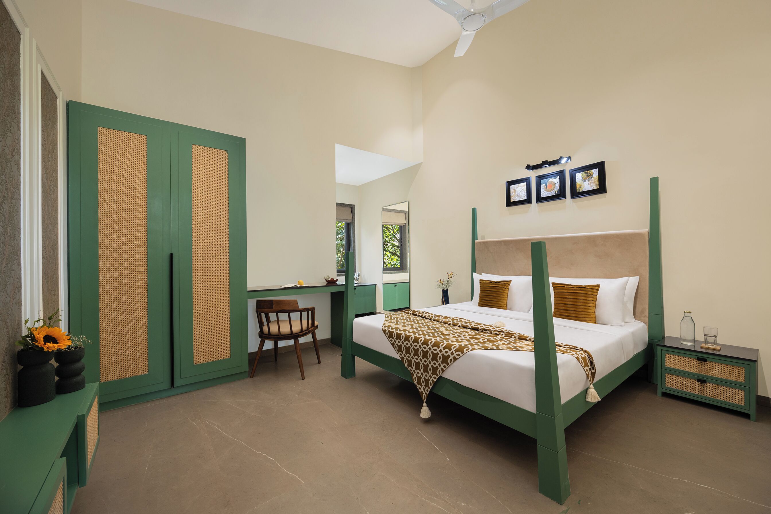 A bedroom with a four-poster bed, a desk, and a chair.