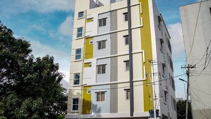 Un edificio de varios pisos con un diseño arquitectónico moderno, que combina colores blanco y amarillo.