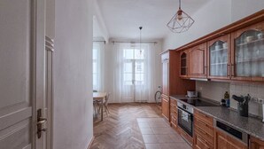 Una cocina con armarios de madera, una encimera y una zona de comedor con una mesa y sillas.