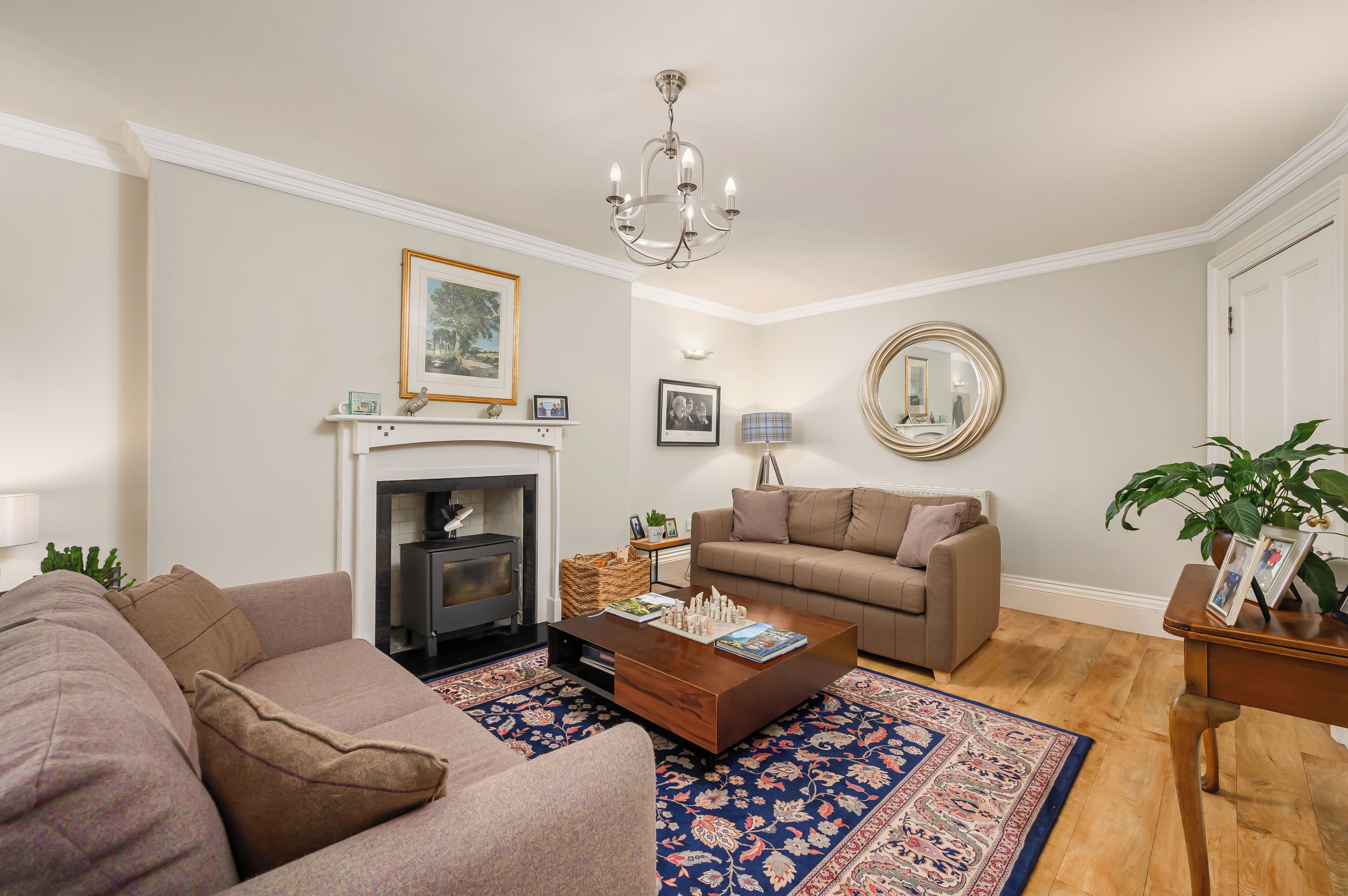 A living room with a fireplace, a sofa, a coffee table, and a rug.