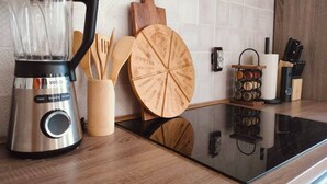 A kitchen with a Bosch blender, wooden cutting board, wooden spoons, and a knife block. - Bright apartment in Mertzwiller (Mertzwiller)