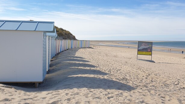 A row of beach huts with a sandy beach and a clear sky in the background. - Sfeervol chalet in Renesse met airco 3 slpk 2 badk (Renesse)