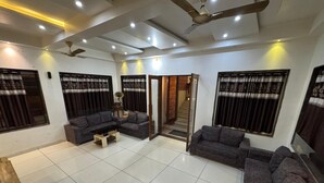 A spacious living room with a sectional sofa, a coffee table, and a staircase leading to an upper floor.