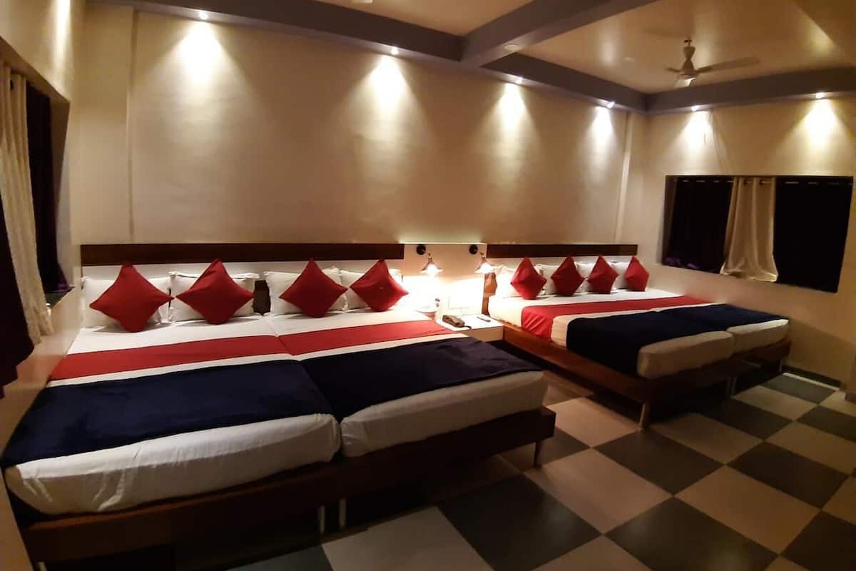 Una habitación de hotel con dos camas, cada una con ropa de cama roja y blanca, y un suelo a cuadros.
