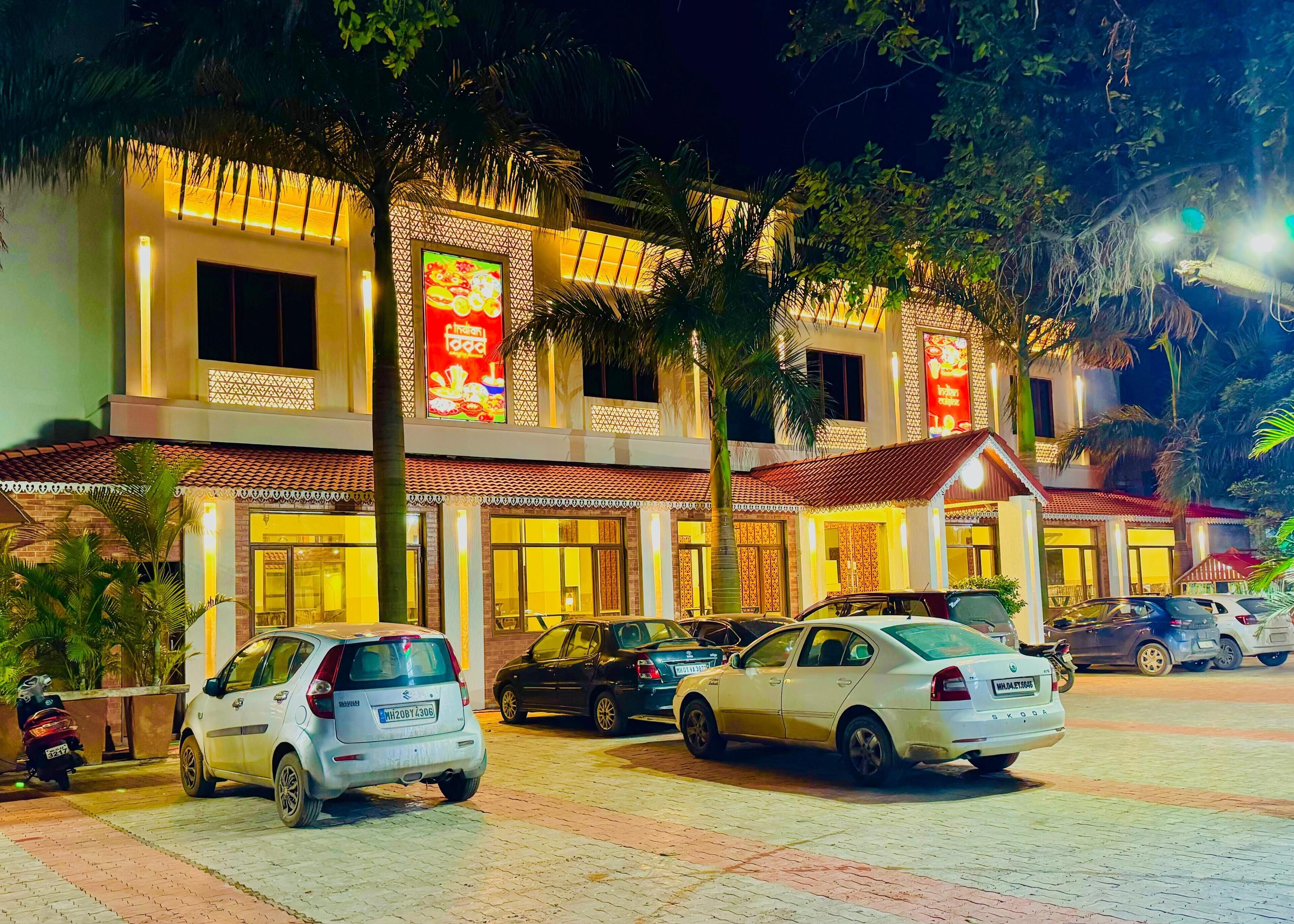 A multi-story hotel with a tiled roof and illuminated signage.