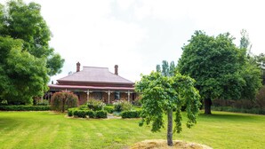 A large house with a red roof, surrounded by well-maintained lawns and trees. - Cosy north facing priv selfcontained Suite set within large garden, 7min to town (Hamilton)