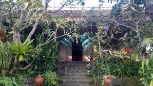 A traditional stone staircase leading to a wooden door with a tiled roof. - Eyang Residence Limasan Kebon Dalem (Prambanan)