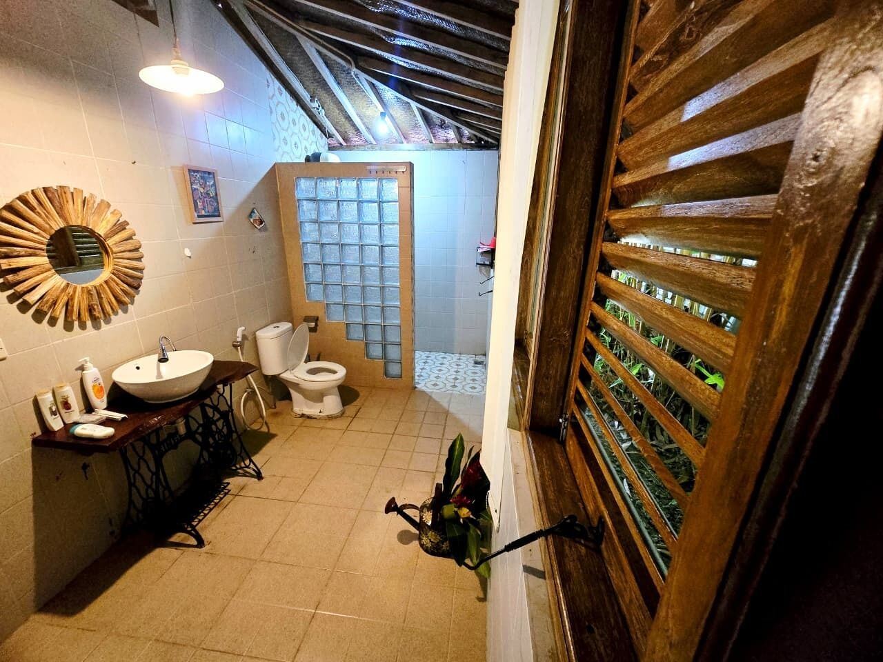 A small bathroom with a sink, toilet, and shower area.