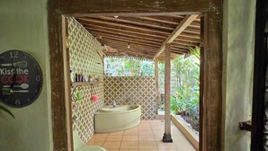 A bathroom with a toilet, sink, and shower area. - Eyang Residence Limasan Kebon Dalem (Prambanan)
