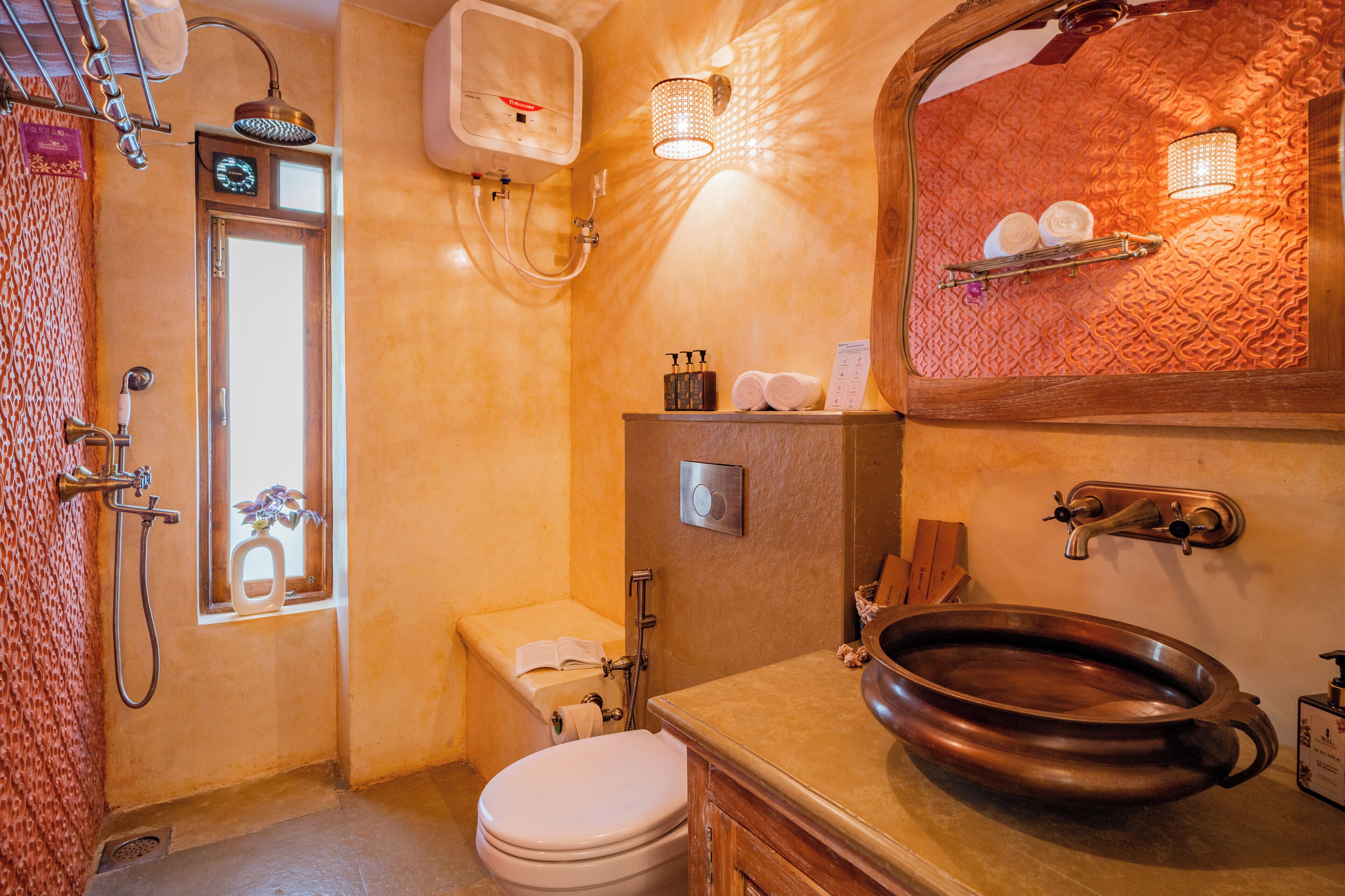 A bathroom with a bathtub, a sink with a large basin, a toilet, and a shower area.